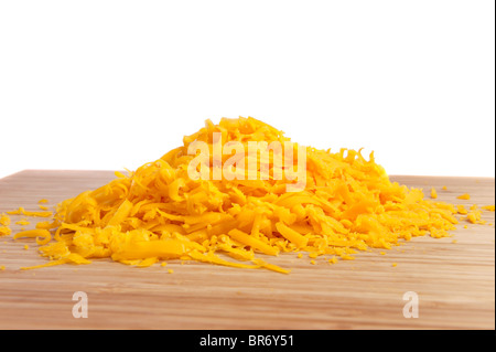 Freshly grated cheese on a cutting board with a white background for use as a design element or copy. Stock Photo