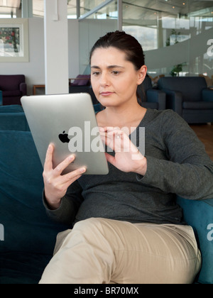 Woman using iPad computer tablet in airport departure lounge Stock Photo