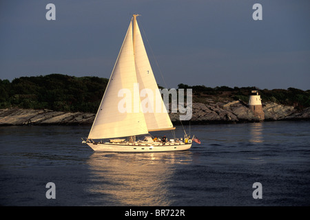 Little Harbor cruising sloop off Castle Hill with lighthouse behind, Newport, Rhode Island, USA. Stock Photo