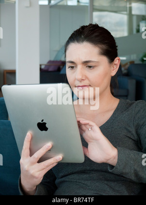 Woman using iPad computer tablet in airport departure lounge Stock Photo