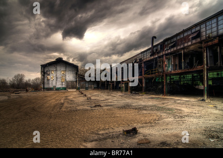 A Collection of Abandoned Industrial Buildings with a Stormy Sky Background Stock Photo