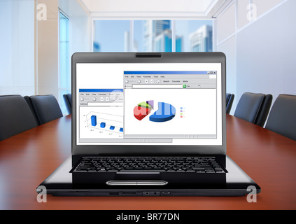 meeting room, in front focus placed on graph shiwing progress on laptop screen Stock Photo