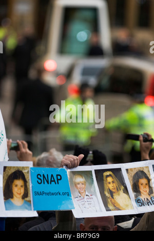 Pope Benedict XVI arrives at Westminster as abuse victims hold up faces of themselves during the papal tour of Britain 2010 Stock Photo