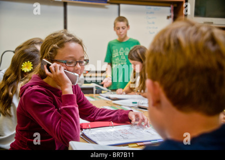 A middle school student uses a cell phone in class in San Clemente, CA. Stock Photo