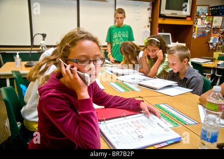 A middle school student uses a cell phone in class in San Clemente, CA. Stock Photo