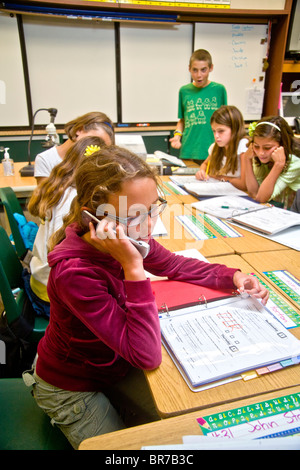 A middle school student uses a cell phone in class in San Clemente, CA. Stock Photo