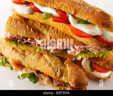 Bread baguettes filled with mozerella & tomatoes, ham & salad, Prcutto ham & rocket. Stock Photo