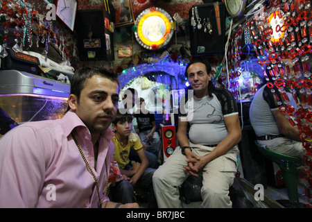 Kurdish people siting in a shop in Qaysari bazaar in the city of Erbil also spelled Arbil or Irbil the capital city of Kurdistan Region in northern Iraq. Stock Photo