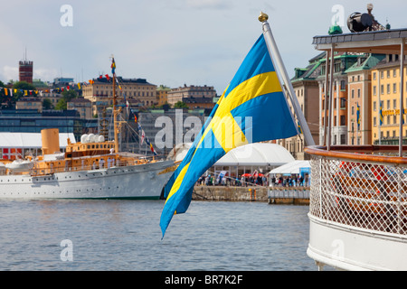 Sweden Stockholm - Swedish flag on one of the many boats anchored at The Old Town - Gamla Stan Stock Photo