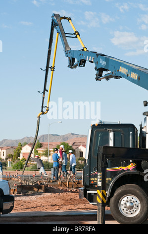 Concrete is pumped and poured for the floor of a new house in Arizona. Stock Photo