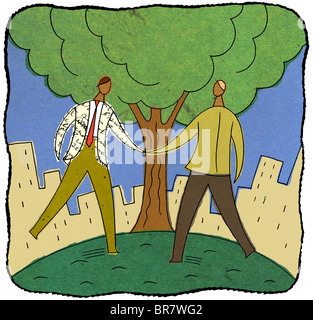 Two businessmen shaking hands under a tree Stock Photo