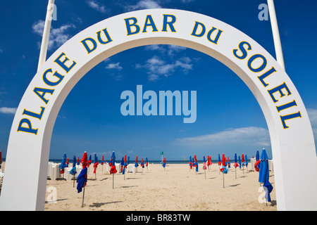 The famous colorful parasols seen through the Plage Du Bar Du Soleil arch on Deauville Beach, Normandy, Northern France, Europe Stock Photo