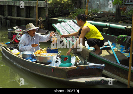 Floating market vendor and customer on a Bangkok canal Stock Photo