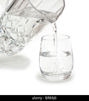 Pouring a glass of cool water from a crystal jug Stock Photo
