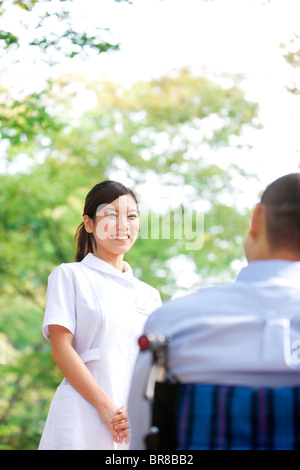 Nurse and man on wheelchair Stock Photo