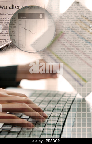 Woman using laptop and newspaper with graph Stock Photo