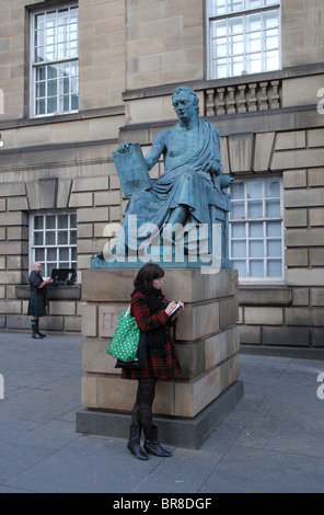 A girl sketching on the High Street in Edinburgh next to the statue of the philosopher and historian David Hume