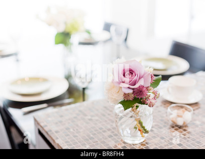 A Bunch of Flowers in a Vase at Dining Table Stock Photo