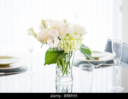 A Bunch of White Flowers in a Vase at Dining Table Stock Photo