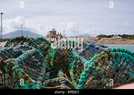 Lobster Pots on Blacksod pier with blacksod lighthouse in the background, The Erris Peninsula, Co. Mayo, Ireland Stock Photo