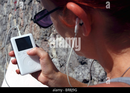 Redheaded woman using an Ipod Stock Photo