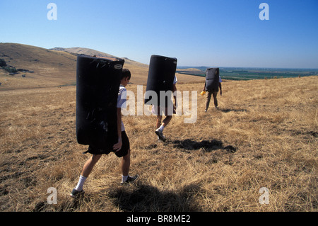Three climbers walking with crash pads in Rocky Hill California. Stock Photo