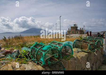 Lobster Pots on Blacksod pier with Blacksod lighthouse in the background, The Erris Peninsula, Co. Mayo, Ireland Stock Photo