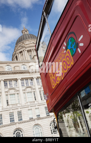 An open topped, red, double decker bus in front of the Port of Liverpool Building in Liverpool