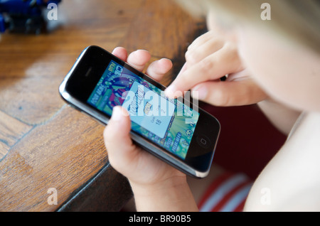 young boy playing ben 10 game on an iphone in ibiza, spain Stock Photo
