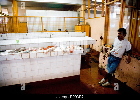 A portrait of a man leaning against his display of fish in a Suva fish market. Stock Photo