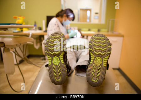 child laying on a table in dentist's office getting work done on his teeth Stock Photo