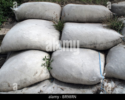 An eroding coastal / river bank with sand bags to prevent flooding and ruin of road and houses. Stock Photo