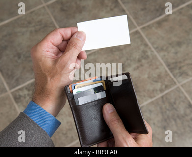 man holding his wallet and extending a blank business card Stock Photo