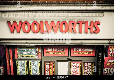 Retail shop WOOLWORTHS going out of business  closing down. Heavy discount signs on window display Last days 80% off Stock Photo