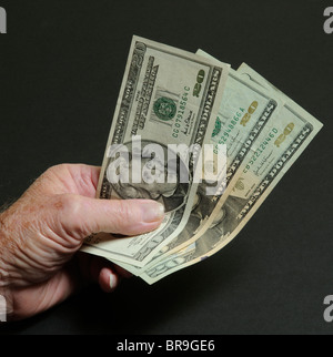 Handful of US Dollars Federal Reserve $20 dollar bills in a man's hand Stock Photo