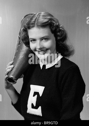 1940s 1950s GIRL CHEERLEADER WITH MEGAPHONE SMILING LOOKING AT CAMERA Stock Photo