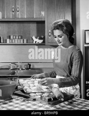 1960s WOMAN HOUSEWIFE BAKING BISCUITS IN KITCHEN Stock Photo