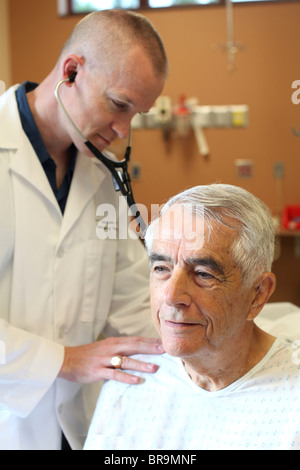 Young doctor listens to young elderly man's breathing Stock Photo