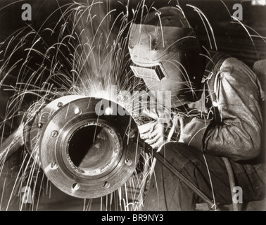 1950s MAN INDUSTRIAL WELDER WELDING PIPE WEARING PROTECTIVE MASK Stock Photo