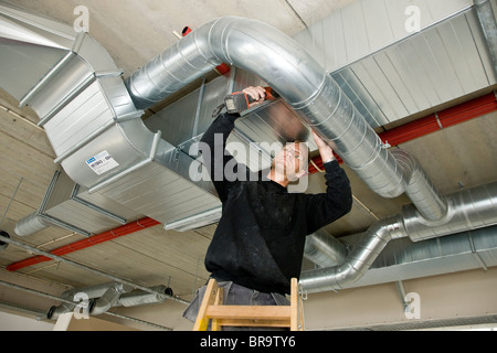 Ventilation fitter installing a ventilation pipe Stock Photo
