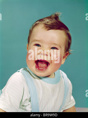 1960s HAPPY SMILING LAUGHING BABY WITH MOUTH WIDE OPEN Stock Photo