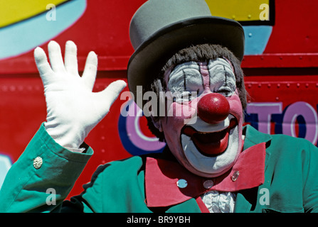 1970s SMILING CLOWN PINK FACE GREEN JACKET WAVING A WHITE GLOVED HAND Stock Photo