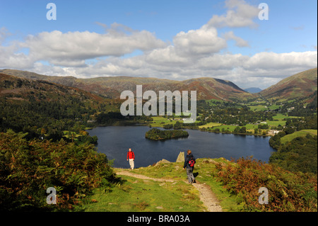 Walkers on Loughrigg Fell overlooking Grasmere near the Lake District village of Ambleside Cumbria UK