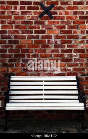 Garden bench in front of a brick wall Stock Photo - Alamy