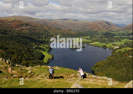 Walkers on Loughrigg Fell overlooking Grasmere near the Lake District village of Ambleside Cumbria UK