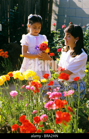 1984 1980s RETRO MOTHER DUAGHTER FLOWERS GARDEN HISPANIC Stock Photo