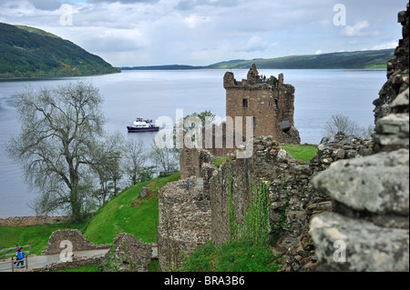 Cruise boat on Loch Ness in front of the ruins of Urquhart Castle near Drumnadrochit, Scotland, UK Stock Photo