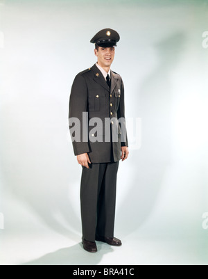 1960s FULL LENGTH PORTRAIT STANDING SOLDIER SMILING ARMY UNIFORM Stock Photo