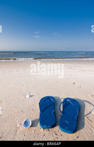 Pair of blue sandals on the sand at Holly Beach near Cameron, Louisiana on the Gulf Of Mexico. Stock Photo