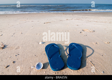 Pair of blue sandals on the sand at Holly Beach near Cameron, Louisiana on the Gulf Of Mexico. Stock Photo